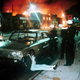 In this August 1965 file photo, police detain a man as buildings burn during rioting that swept the Watts district of Los Angeles. It began with a routine traffic stop, blossomed into a protest and escalated into the deadliest and most destructive riot Los Angeles had seen. The Watts riot broke out Aug. 11, 1965 and raged for most of a week. When the smoke cleared, 34 people were dead, more than 1,000 were injured and some 600 buildings were damaged.